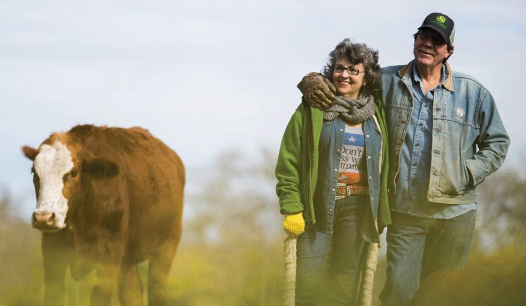 Renee and Tommy of the Rowdy Girl Sanctuary with a cow who is a family member, not a product.