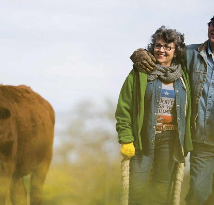 Renee and Tommy of the Rowdy Girl Sanctuary with a cow who is a family member, not a product.