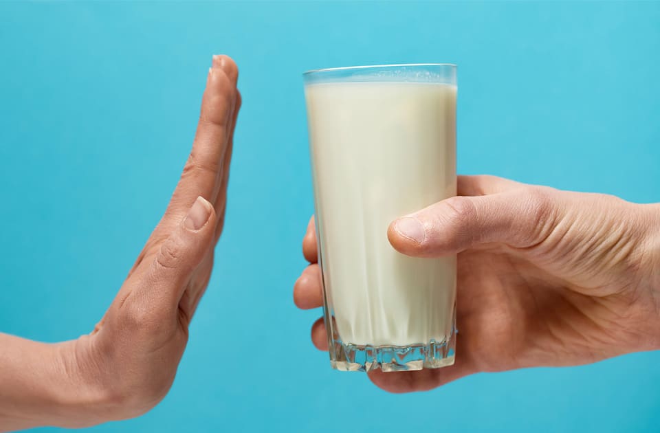 Glass of milk and hand showing stop