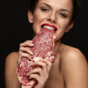 Woman Biting Raw Red Beef Steak Meat