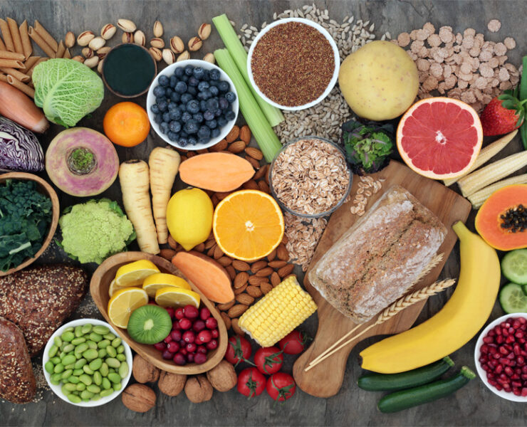 High-fibre super food with whole grain bread loaf and rolls, fruit, vegetables, whole wheat pasta, cereals, seeds and nuts.