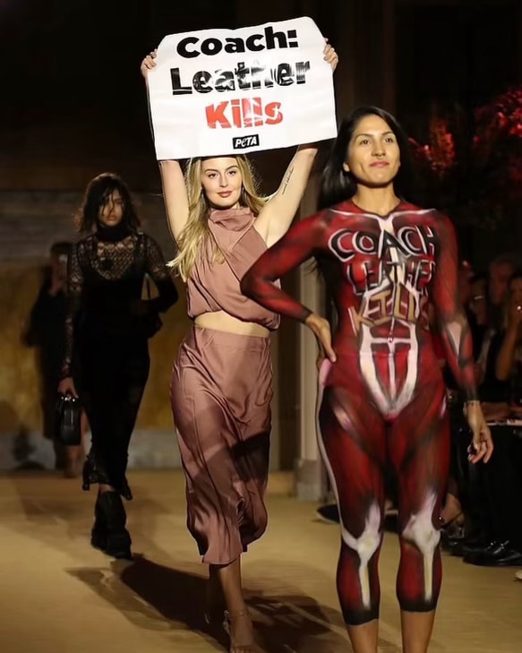 Jamie Logan holding Leather Kills sign on the runway at New York Fashion Week. 